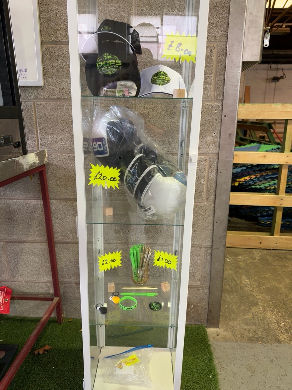 Pops merchandise cabinet with caps, boxing gloves and small branded items